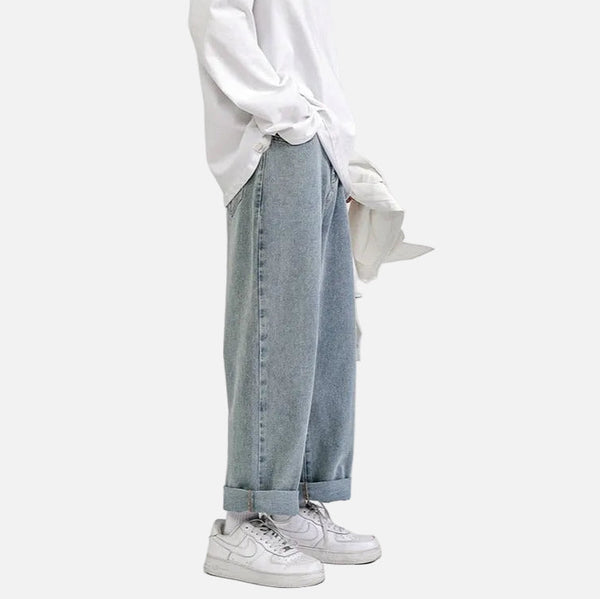 White long-sleeve shirt, wide light blue jeans, white Nike shoes, white background.