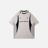 Front view of the beige Vintage Sports Patchwork Polo T-Shirt in a gray background 