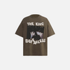 Front view of the brown The King Be Fearless Graphic T-shirt in a gray background
