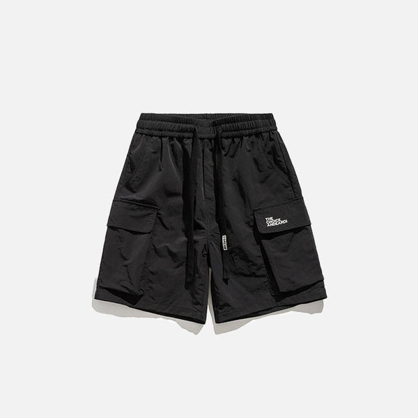 Front view of the black Essential Utility Cargo Shorts in a gray background