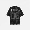 Back view of the black Vintage Graphic Printed Grunge T-Shirt in a gray background