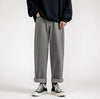 Dark sweater, wide grey jeans, black Converse shoes, minimalist white background.