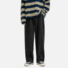 Blue beige striped long-sleeve shirt, wide black jeans, black Converse, white background.