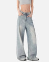 Model wearing the blue Oversized Denim Flares Jeans in a gray background