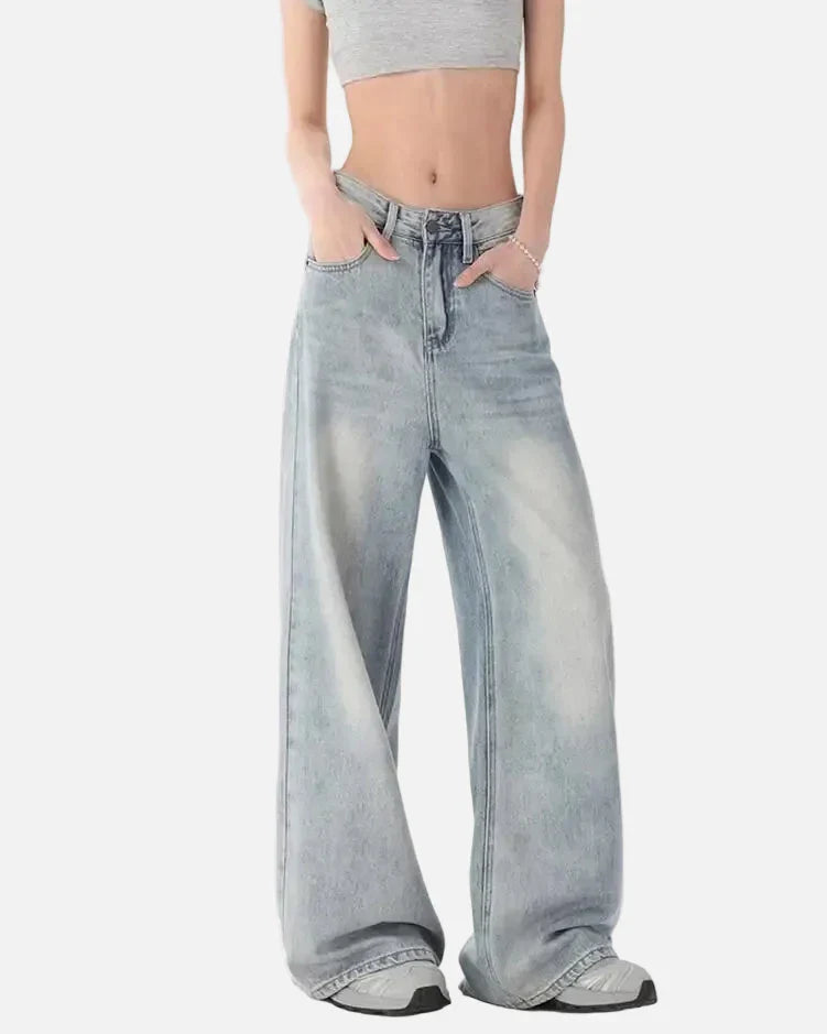 Model wearing the blue Oversized Denim Flares Jeans in a gray background