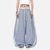 Person wearing blue plaid pants with white stripes on a white background