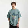 Model wearing the blue gray Style Sphere T-Shirt in a gray background
